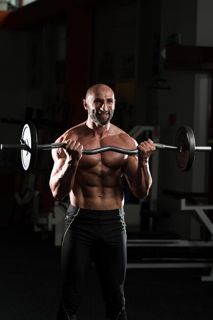 Hombre sano trabajando bíceps en un club de salud