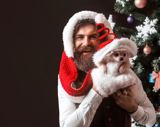 Hombre de santa claus con celebración de fiestas de perro mascota y navidad con mascotas pomeranian spitz