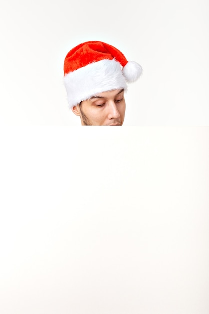 Hombre de Santa con sombrero rojo de Navidad para vacaciones de año nuevo con hoja de papel blanco aislado sobre fondo blanco, espacio de copia.