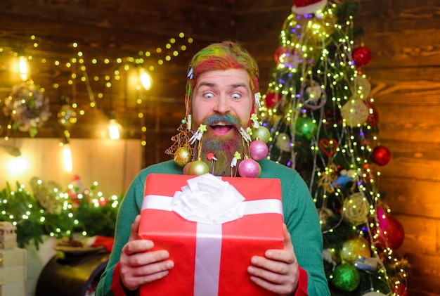 Hombre de santa sorprendido con regalo de navidad hombre barbudo con barba decorada mantenga caja de regalo de navidad