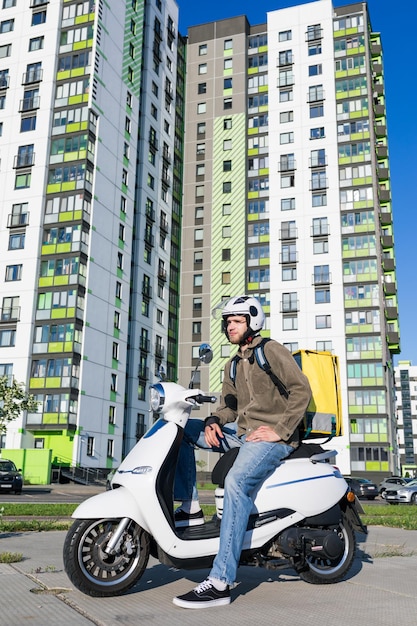 Un hombre en un scooter un repartidor de comida Empresa de entrega de comida rápida