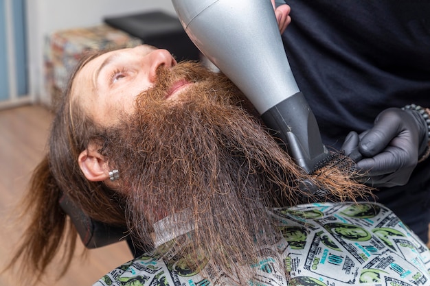 Hombre secándose la barba en el peluquero.