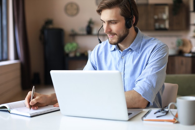 Hombre seguro con auriculares hablando y viendo la formación de seminarios web de negocios, escuchando una conferencia.