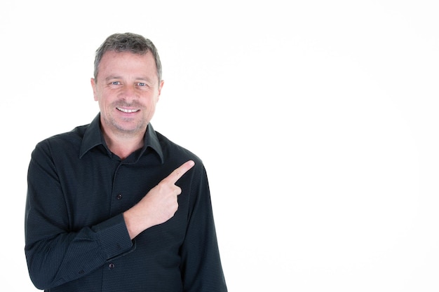 El hombre señala con el dedo hacia un lado para presentar un espacio vacío en blanco para el producto o el signo