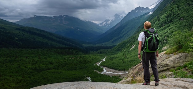 Hombre de senderismo en las montañas con mochila pesada