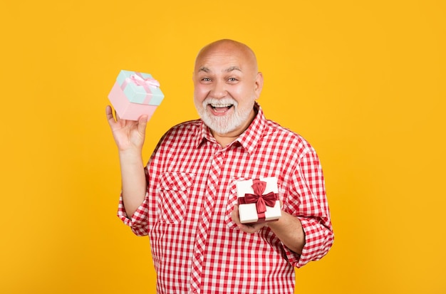 Hombre senior alegre con caja de regalo para aniversario