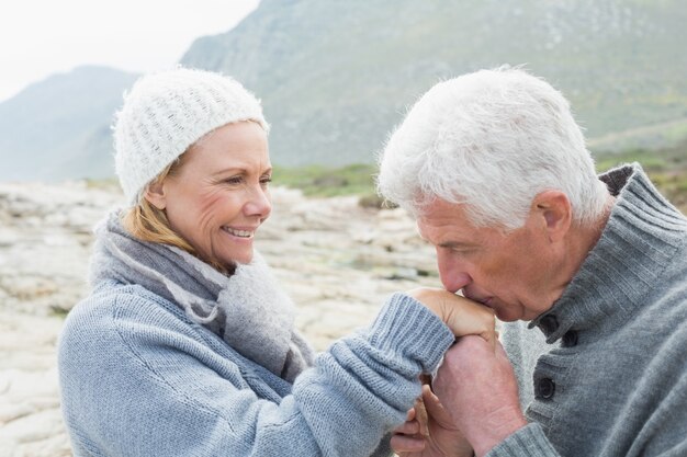 Hombre Senior besando la mano de mujer feliz