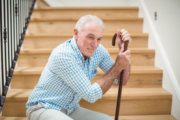 Hombre senior cansado sentado en las escaleras