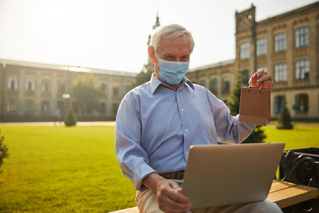 Hombre senior comprobando los resultados de salud en línea con un portátil