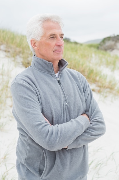 Hombre senior contemplativo en la playa