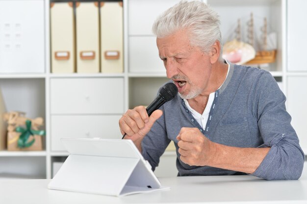 Hombre senior emocional cantando karaoke