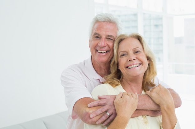 Hombre senior feliz abrazando a la mujer por detrás