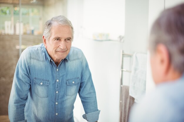 hombre senior sonriente en espejo