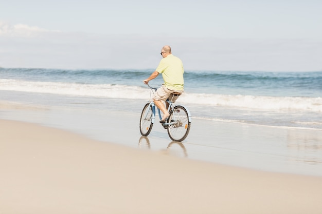 Hombre senior sonriente montando bicicleta