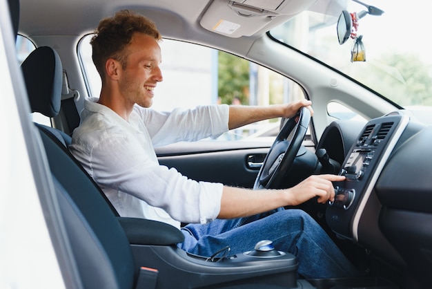 Hombre sentado al volante de un coche eléctrico