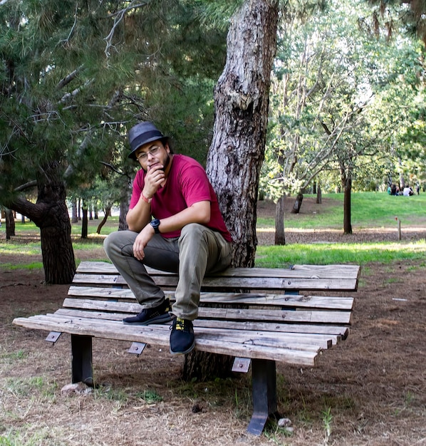 Foto hombre sentado en un banco en el parque