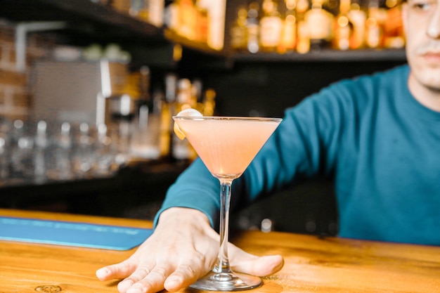 Hombre sentado en el bar sosteniendo una bebida