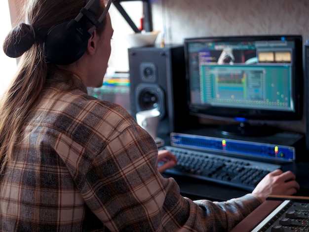 Hombre sentado en casa estudio con equipo de música profesional