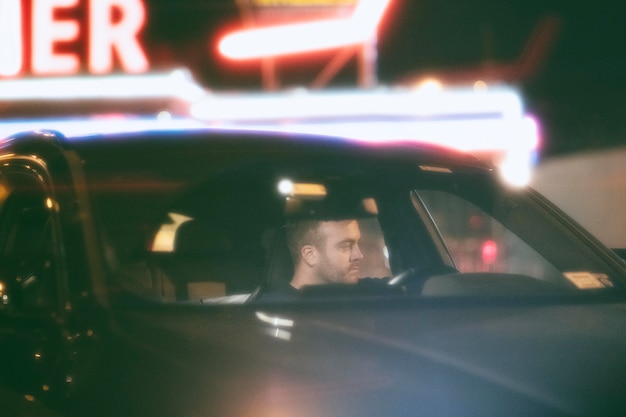Hombre sentado en el coche por la noche