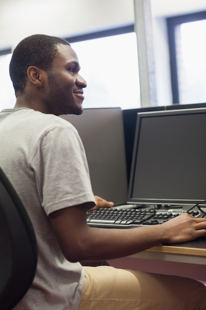 Hombre sentado en la computadora sonriendo