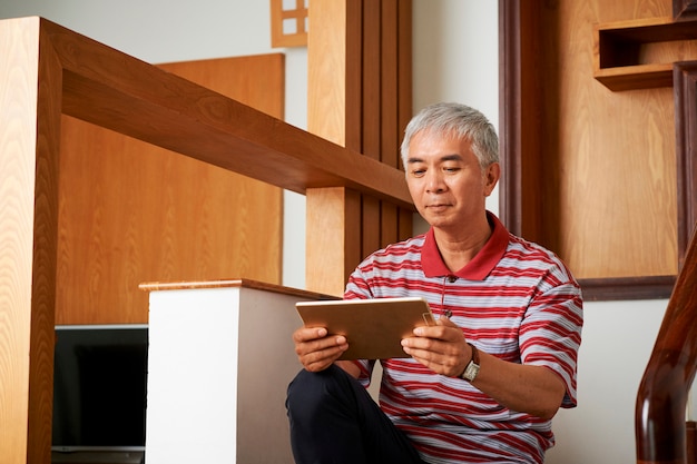 Hombre sentado en las escaleras con tablet pc