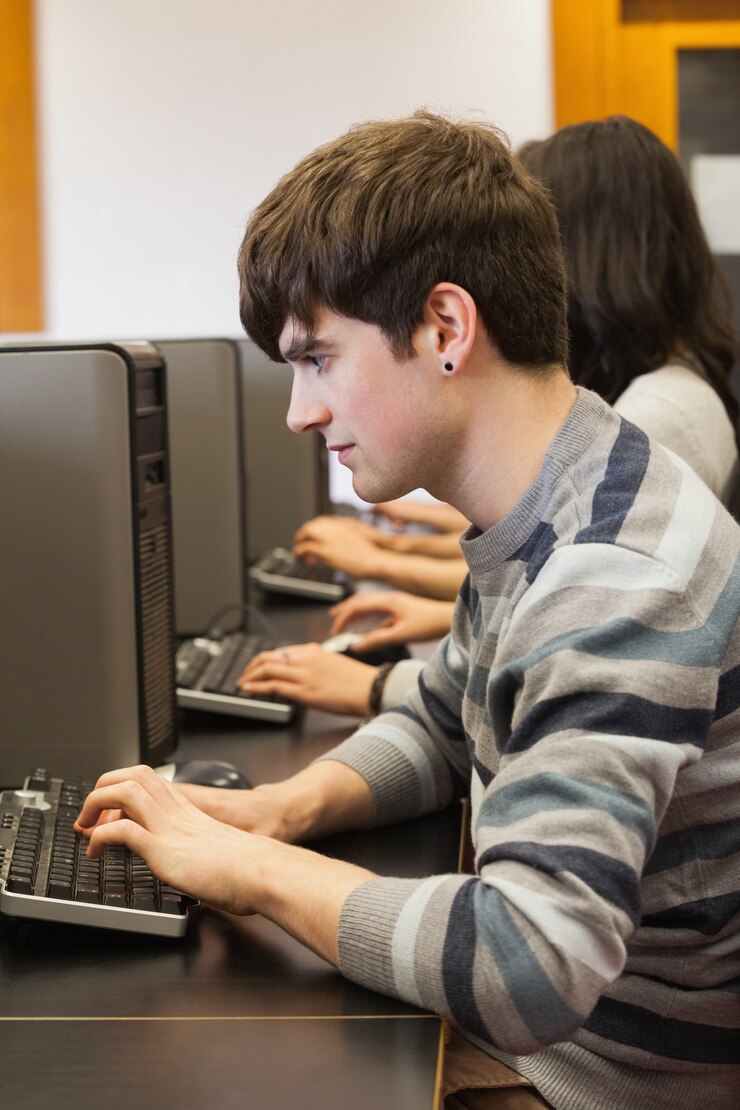 Foto hombre sentado en el escritorio de la computadora escribiendo