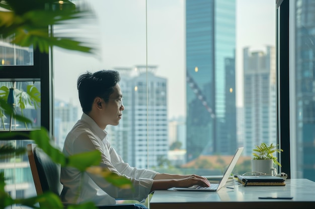 Hombre sentado en un escritorio usando una computadora portátil