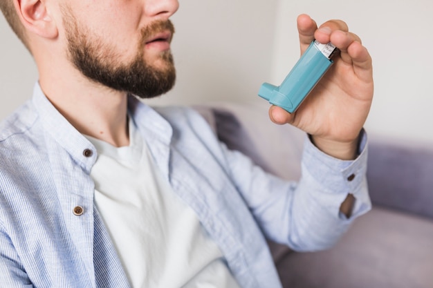 Foto hombre sentado con inhalador