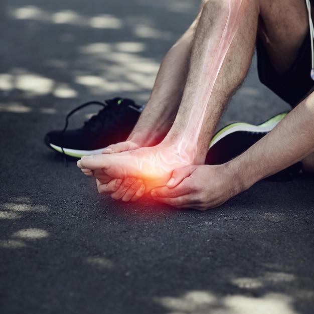 Hombre sentado y lesión en el pie en el ejercicio de entrenamiento y entrenamiento urbano al aire libre en la calle con zapatos deportivos Carretera de corredor saludable y dolor en los pies articulares y descanso después de correr en metro para el bienestar corporal