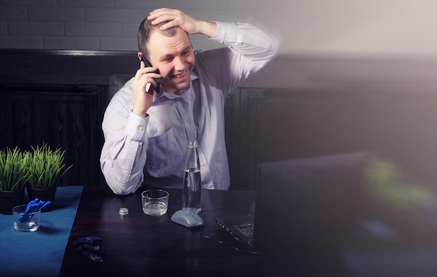 Hombre sentado a la mesa y trabajando en equipo portátil