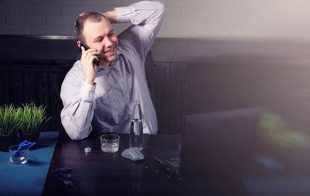 Foto hombre sentado a la mesa y trabajando en equipo portátil