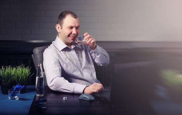 Hombre sentado a la mesa y trabajando en equipo portátil