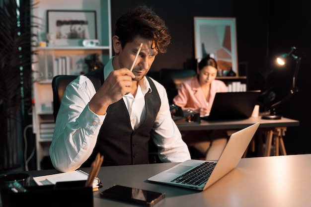 Foto hombre sentado pensando en proyectos de negocios creativos planeando por la noche postulado