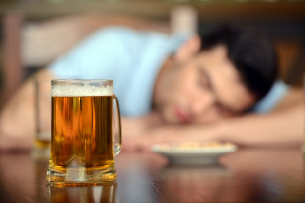 Hombre sentado en el pub con los ojos cerrados.