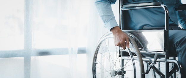 Hombre sentado en una silla de ruedas hombre con silla de ruedas en la oficina de la empresa reclutando personas con discapacidad para trabajar con un equipo en la empresa y tener una persona discapacitada como parte del equipo