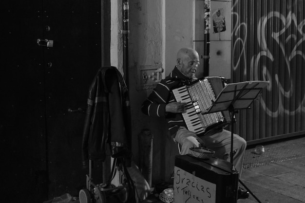 Hombre sentado en una silla tocando el acordeón