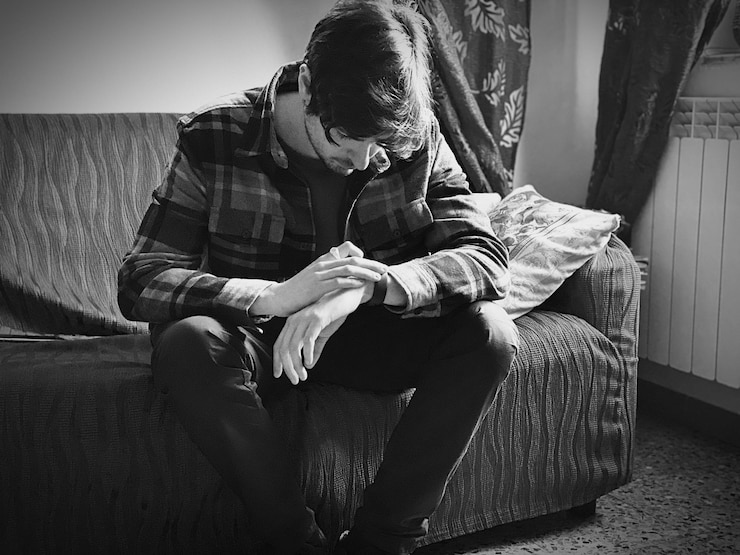Foto hombre sentado en el sofá en casa