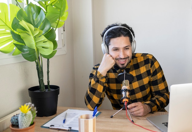 Hombre sentado en su oficina hablando por un micrófono con auriculares