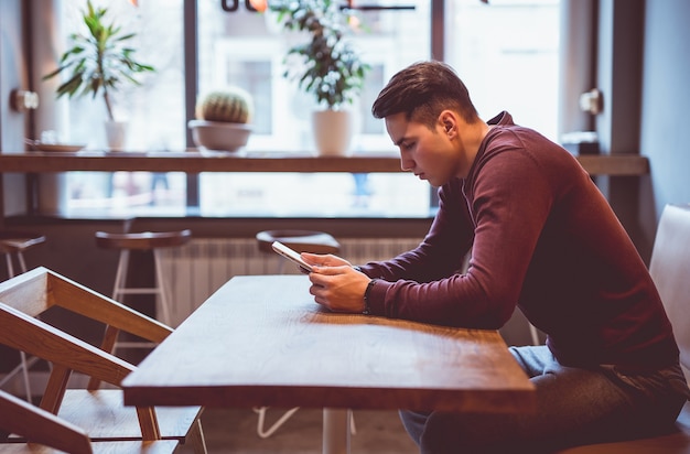 Foto el hombre sentado con una tableta en la mesa de café