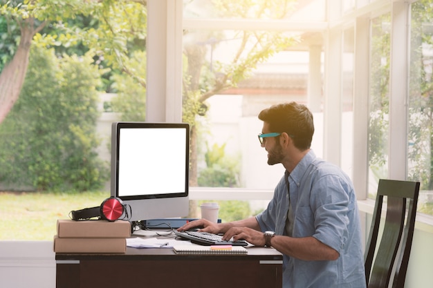 Hombre sentado trabajando con la computadora.