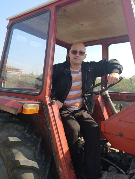 Foto hombre sentado en el tractor