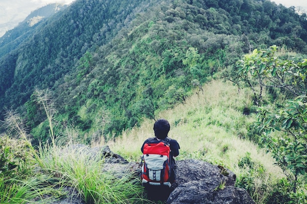 Hombre sentado en viajes de aventura de montaña