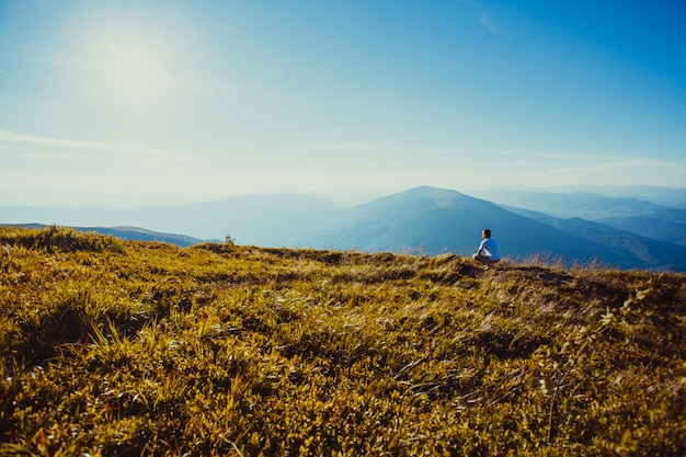 El hombre se sentó en la cima de la montaña. Inspiración de la naturaleza y viajes, telón de fondo para la motivación y el concepto de letras