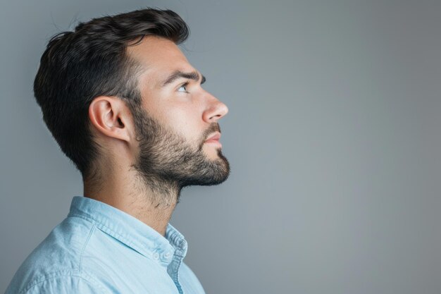 Foto hombre serio y confiado con camisa azul en un retrato de fondo gris