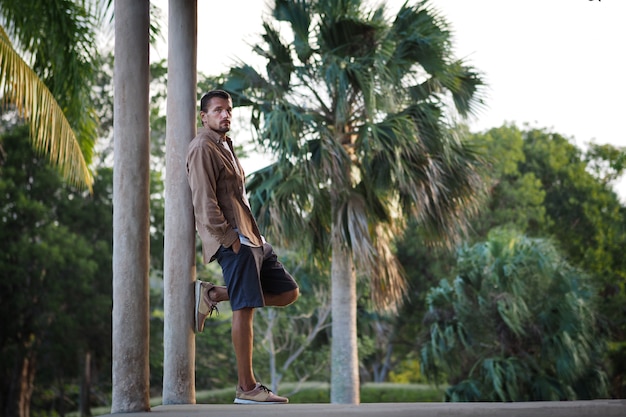 Hombre serio en una escena tropical. La luz del atardecer.