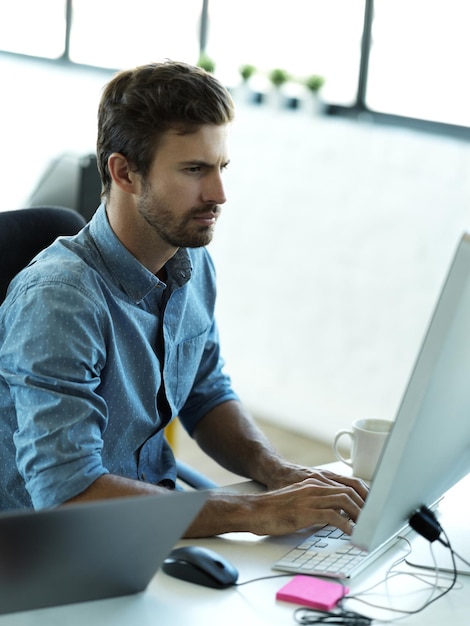 Foto hombre serio escribiendo en computadora y planeando negocios web un diseño de sitio web en la oficina inicio de gestión de contenido y empleado en tecnología trabajando en diseño de estrategia creativa con software tecnológico