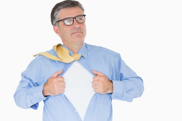 Hombre serio con gafas está tirando de su camisa con sus manos