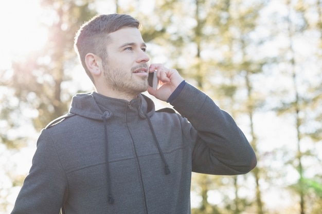 Hombre serio que usa el teléfono móvil al aire libre