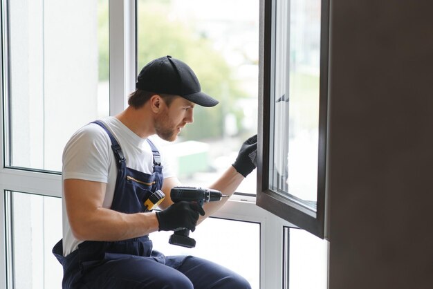 hombre de servicio instalando ventana con cinta métrica