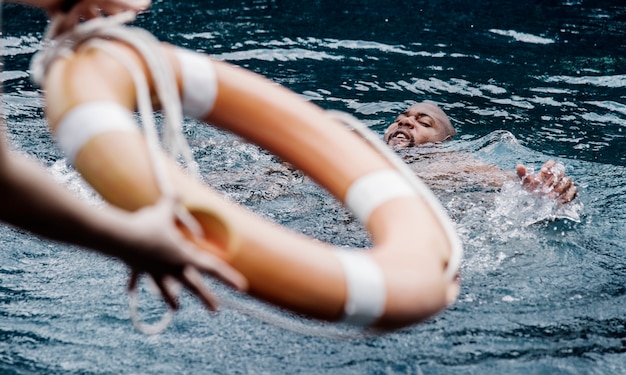 Hombre siendo rescatado del agua.